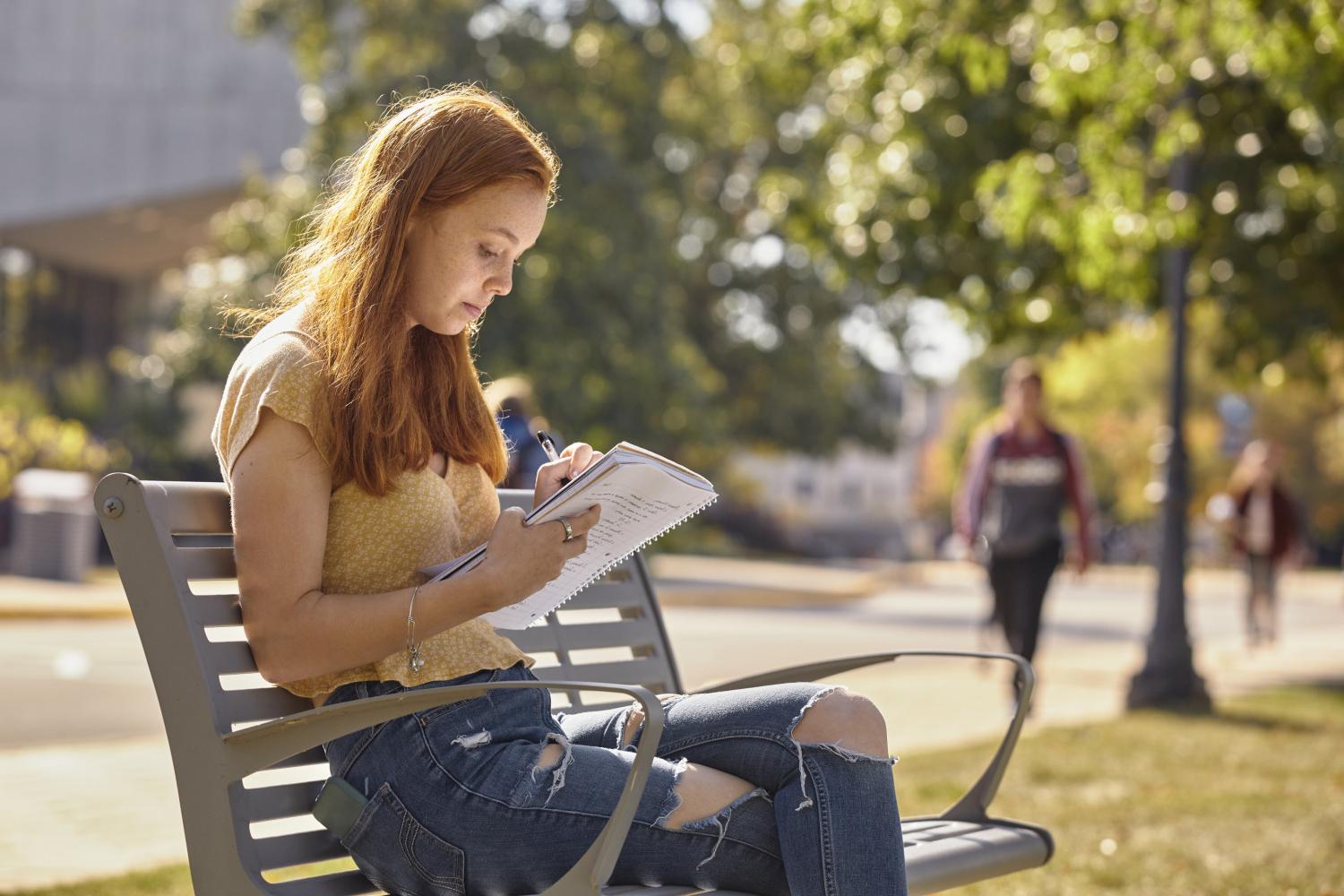 一位<a href='http://gr.goudounet.com'>全球十大赌钱排行app</a>学院的学生在校园里的长椅上读书.